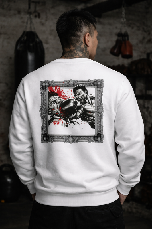 Person wearing a white sweatshirt with a graphic design on the back in a boxing ring setting.