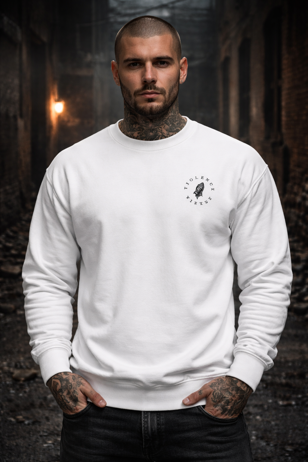 Man wearing a white sweatshirt with a logo in a dark, forest-like setting